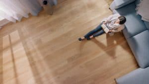oil for wood floors | woman sitting on wood floor in home
