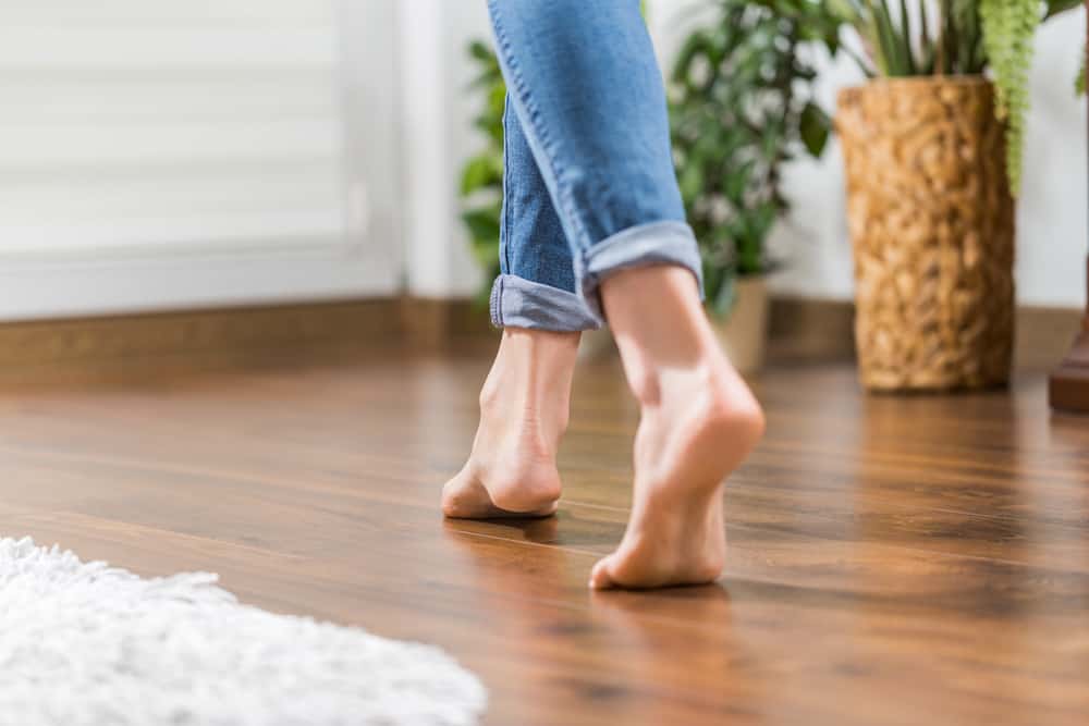How Long Should Hardwood Floors Last | person walking on wood floors