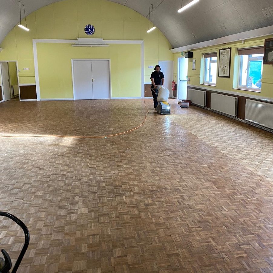 Different Types of Commercial Wood Flooring | team member sanding commercial floor