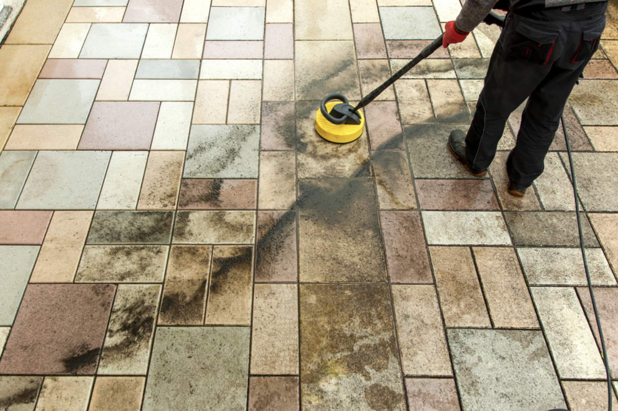 Person cleaning floor with pressure washer