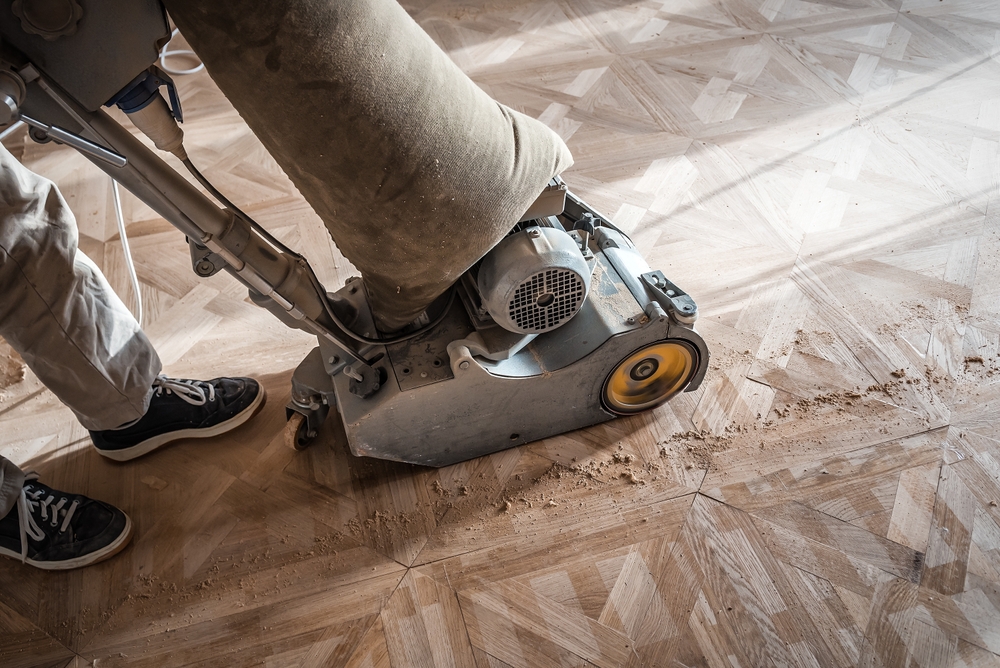 Person using a sanding machine on a floor